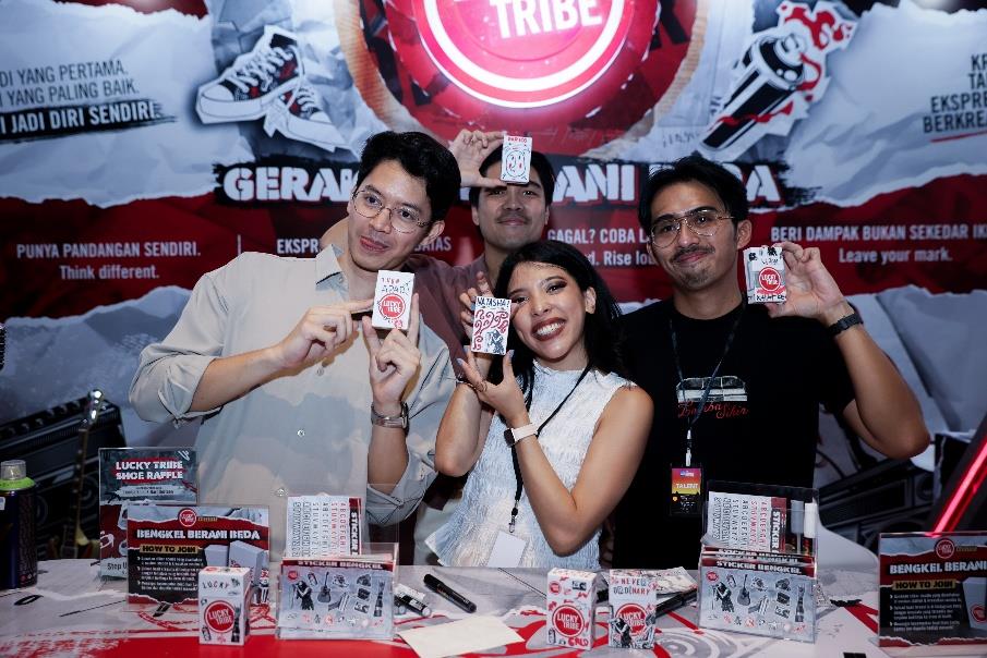 Personel Lomba Sihir di area Lucky Tribe memegang sticker bengkel