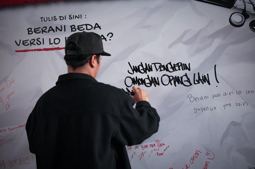 Pengunjung menulis pesan di Tembok Berani Beda